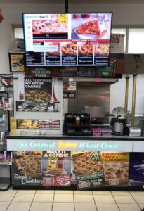 Hunt Brothers Pizza Vegetarian Options Sign Outside a Convenience Store