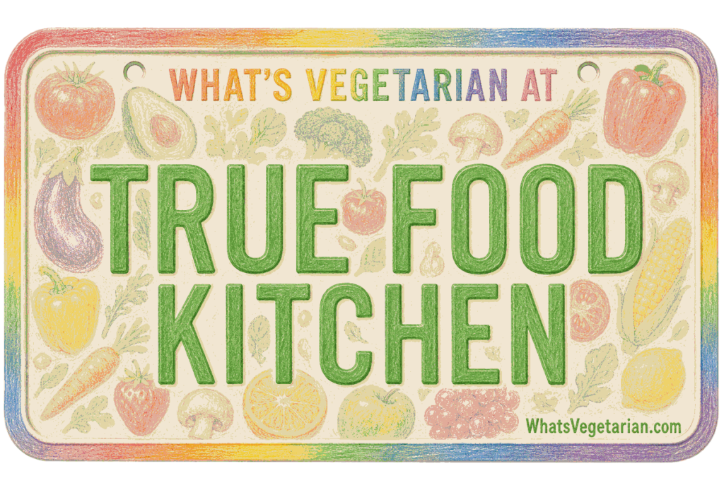 Colorful sign that reads 'TRUE FOOD KITCHEN' with 'WHAT'S VEGETARIAN AT' at the top and a vegetable border around the edge.