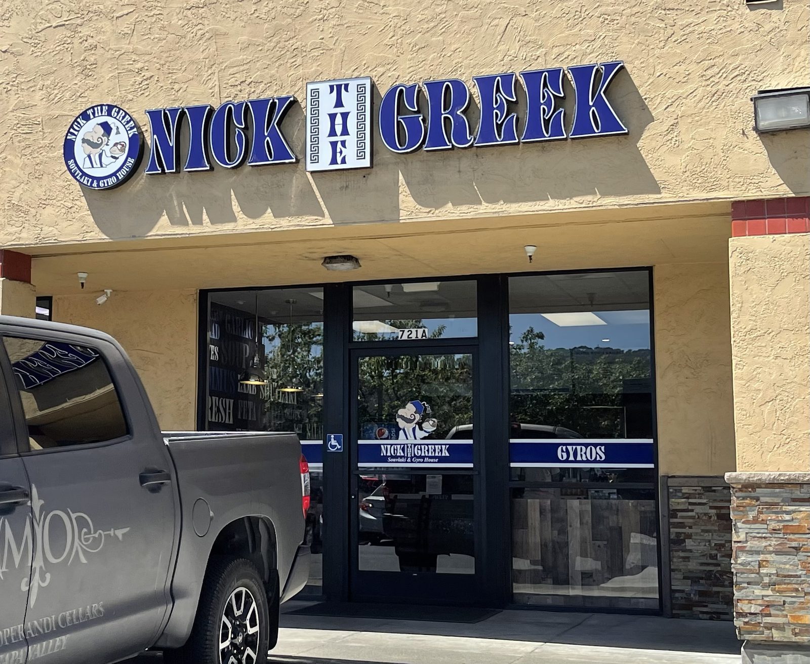 Interior of a Nick the Greek restaurant, where nick the greek vegetarian options include falafel, hummus, and build-your-own bowls