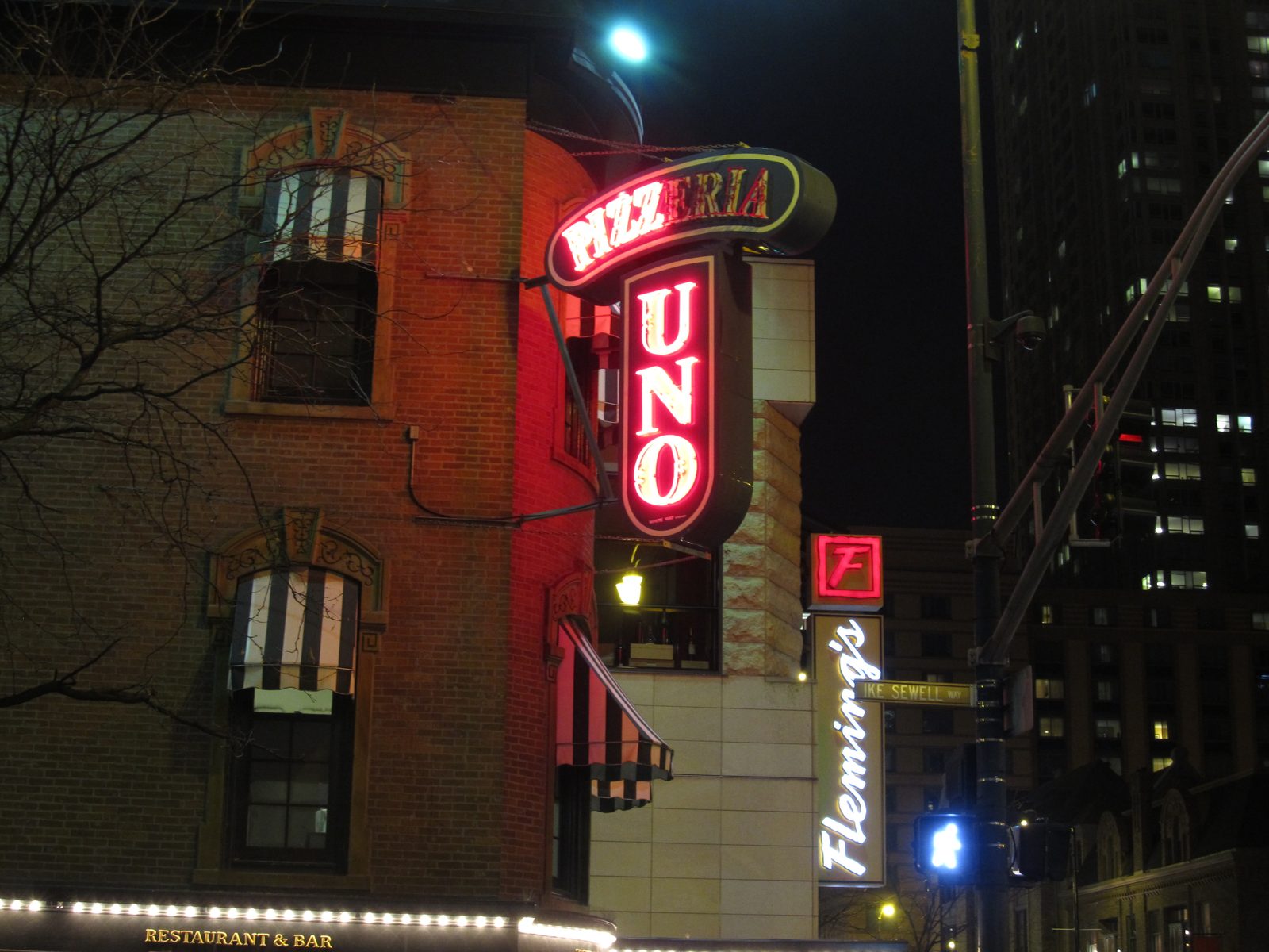 Uno Pizzeria and Grill original storefront sign at night in Chicago